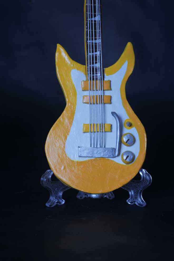 Guitare jaune fond noir gros plan redimensionnée .jpeg